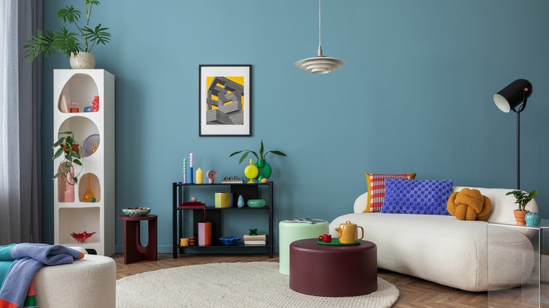 Oturma odasında sade çizgilere ve renk tonlarına sahip mobilyalar bulunur.