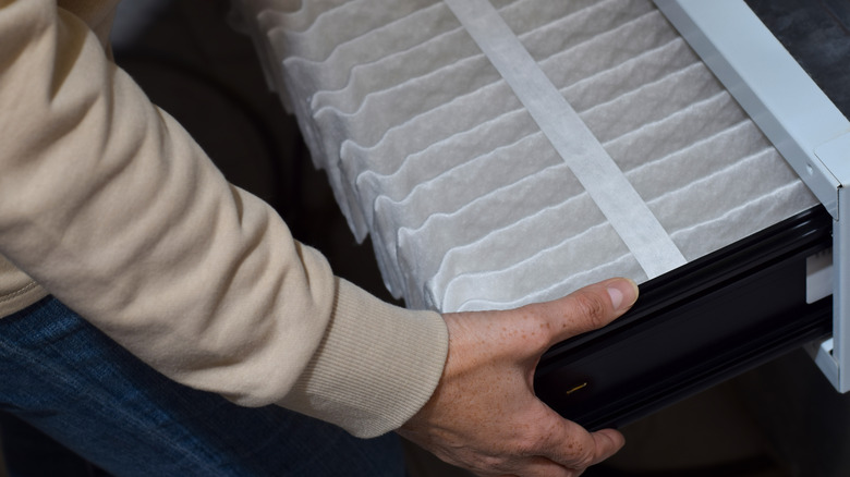 Pileli bir fırın filtresi kuran bir kişi