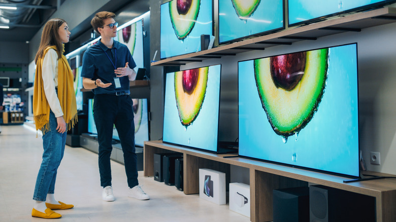 Bir mağazadaki televizyon ekranına bakan insanlar