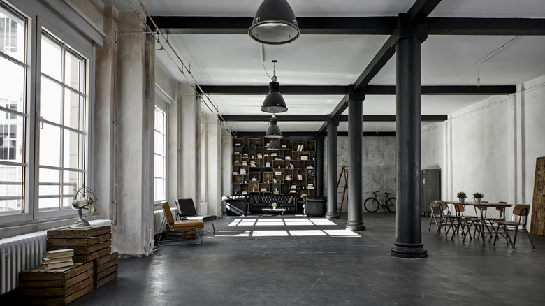 Beton zeminli, ahşap kutuları ve bir kitap kasası olan bir endüstriyel çatı katı dairesi