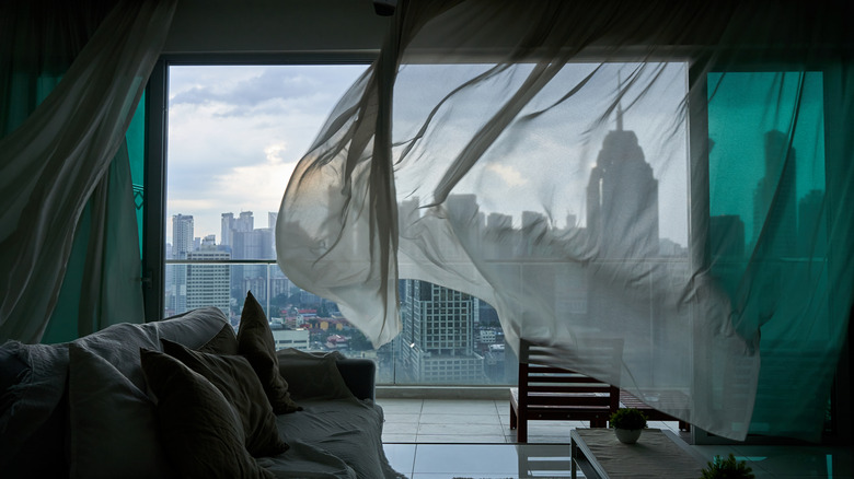 Rüzgar bir oturma odasında perdeleri esiyor