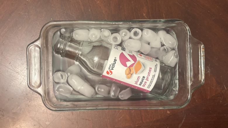 Buzlu suya batırılmış bir ekmek tavasında erik sosu şişesi