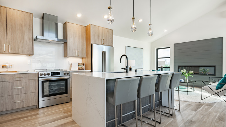 İyi aydınlatılmış bir mutfak, adanın üstünde üç asılı ışık içerir