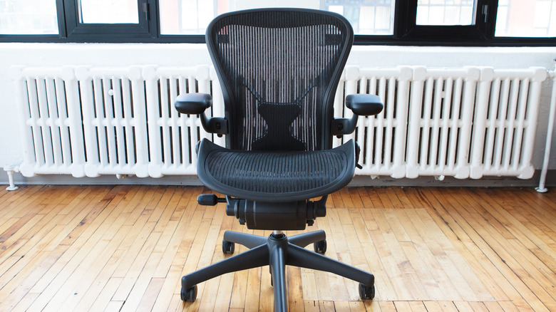 Bir parke zeminde çoklu ayarlanabilir özelliklere sahip bir ofis sandalyesi