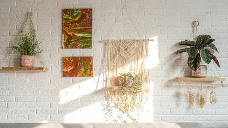 Bir makrome, beyaz bir duvarda ahşap bir dübenden asılır.