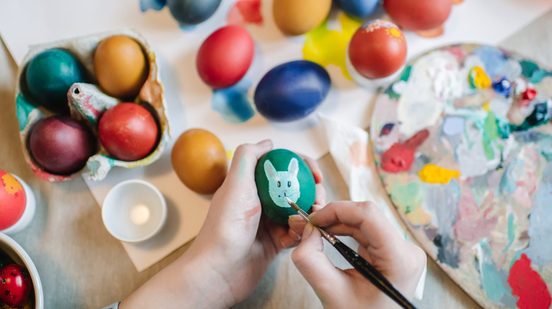 Bir kişi Paskalya dekoru için yumurta boyama