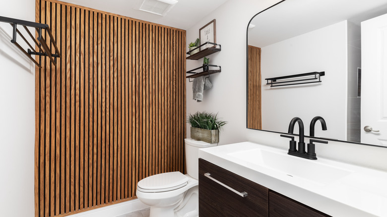 Ahşap vurgu duvarı olan bir banyo.