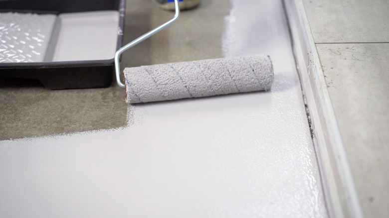 Beyaz epoksi garaj zemin kaplamasını uygulayan silindir