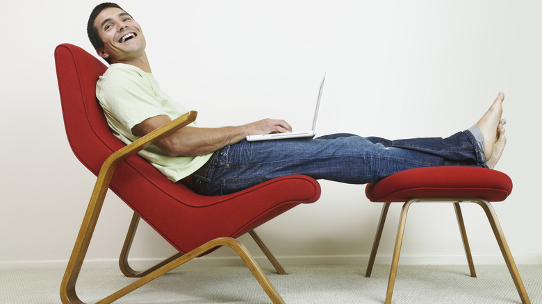 Yüzyılın ortalarında modern bir şezliye uzanırken gülüyor bin yıllık bir adam