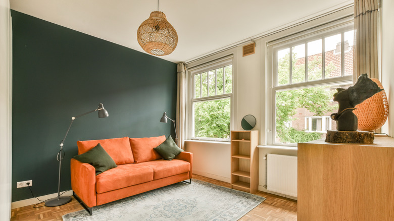 Koyu yeşil vurgu duvarı ile boyanmış küçük bir oturma odası