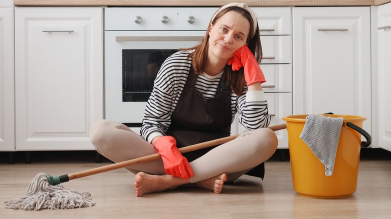 Apron temizleme mutfak zeminde mutsuz bir kadın