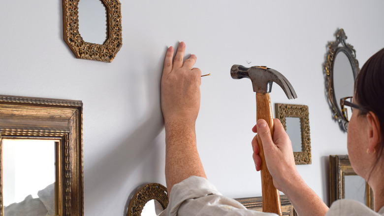 Duvarda aynalar asılı kadın