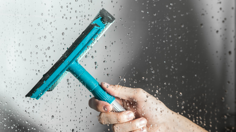Su damlacıkları ile bir duş kapısı silme