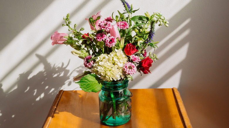 Güneş ışığında bir vazoda beyaz ve pembe çiçekler