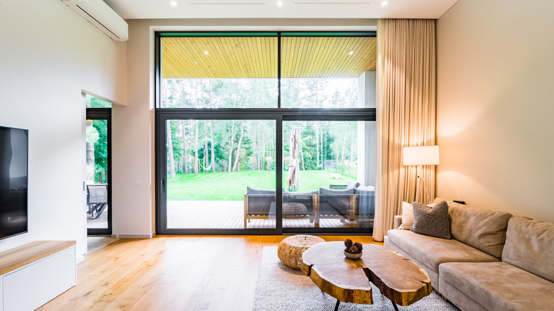 Büyük pencereler ve kalın zemin uzunluğu perdeleri olan oturma odası