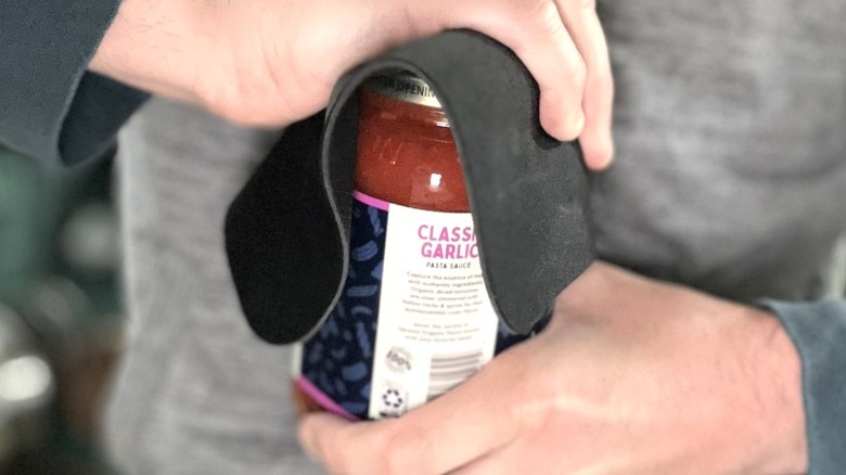 Kişi açılan kişi, kavrama için fousepad ile makarna sosu kavanozu