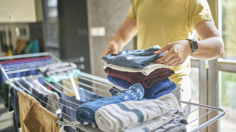 Kurutma rafına kıyafet ekleyen kişi