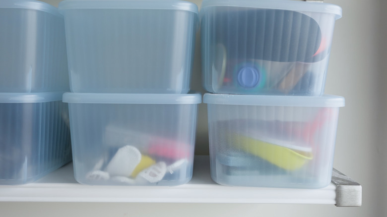 Bir rafta şeffaf depolama kutuları