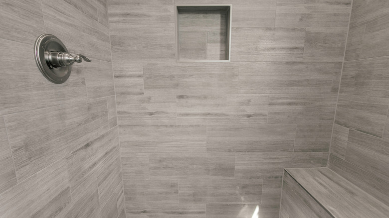 Gri kiremitli bir duş yerleşik bir niş ve tezgah içerir