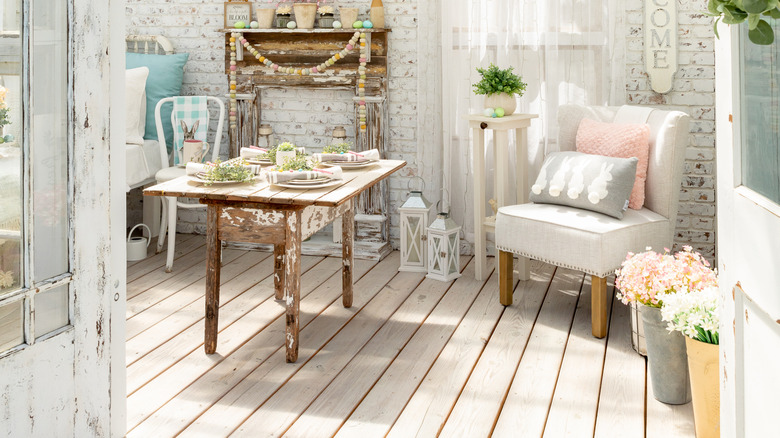 Beyaz temalı bir odada sıkıntılı ahşap masa ve sahte mantel