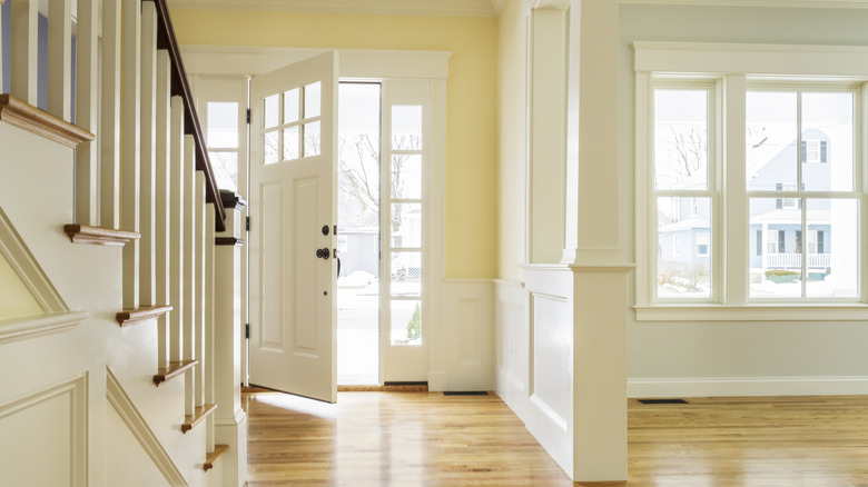 Soluk sarı duvarlarla ön kapı ve giriş yolu.