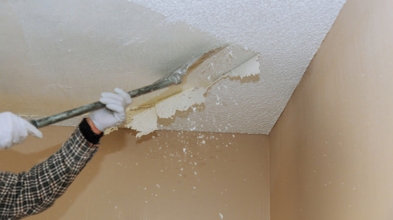 Bir kişi patlamış mısır tavanı kazıyarak eldiven giyer