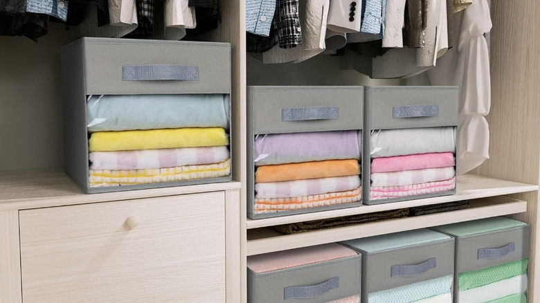 Şeffaf pencerelere sahip gri depolama küpleri bir dolap rafında istiflenir.