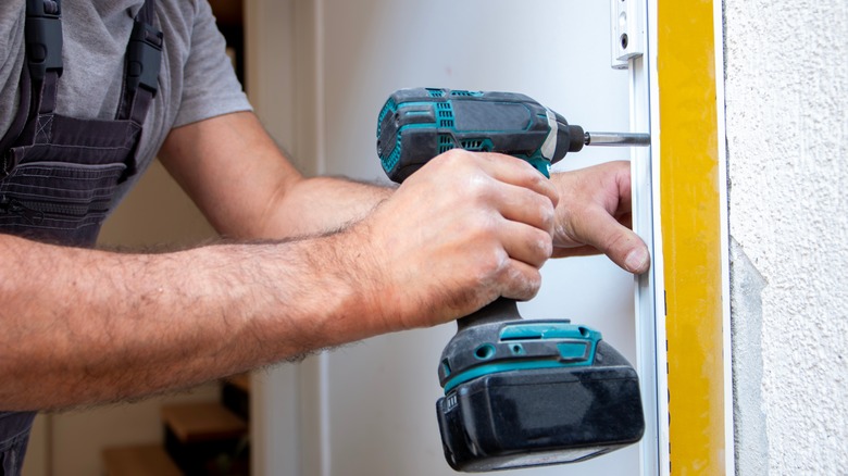 Bir kapı çerçevesine delen bir adam