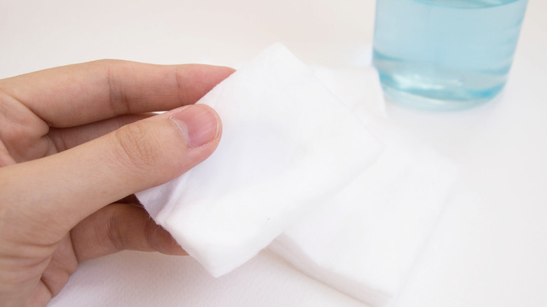 Elde tutan pamuk karesi şişe sürtünme alkolünün yanında