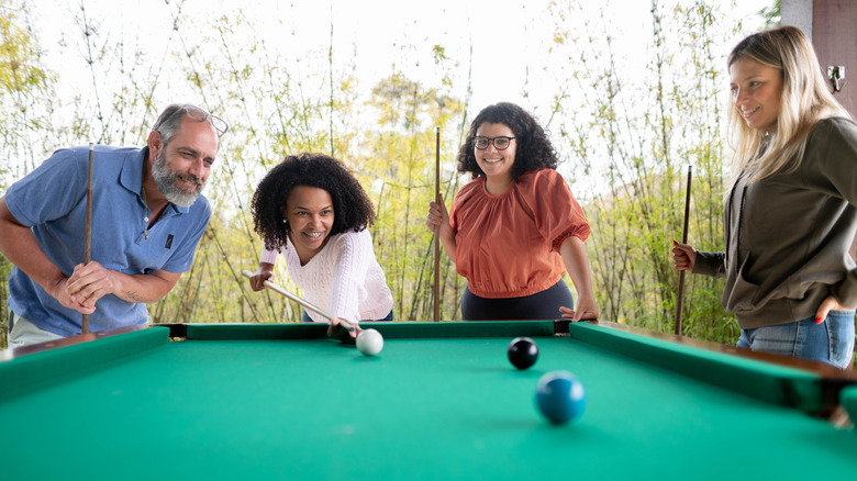 Dışarıda havuz oynayan dört kişilik grup