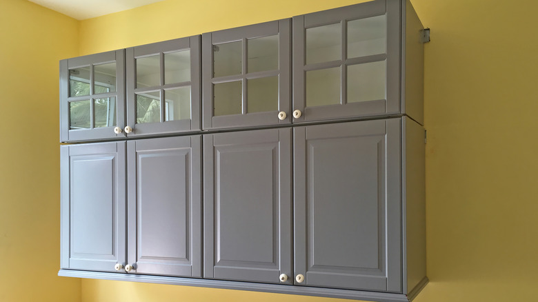 Sarı duvarın önüne iki katlı dolap duvara monte edilmiş iki katlı dolap