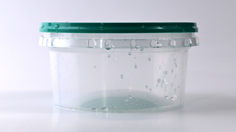 Üzerinde su damlası olan plastik kap