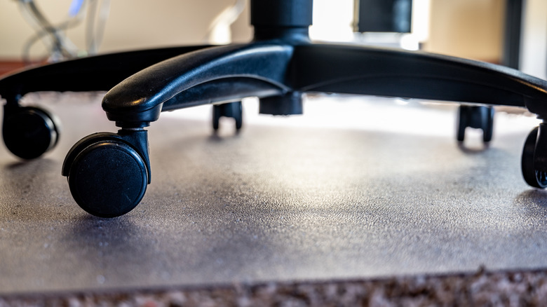 Üstünde silindir tekerlek sandalyesi olan bir ofis vinil matının