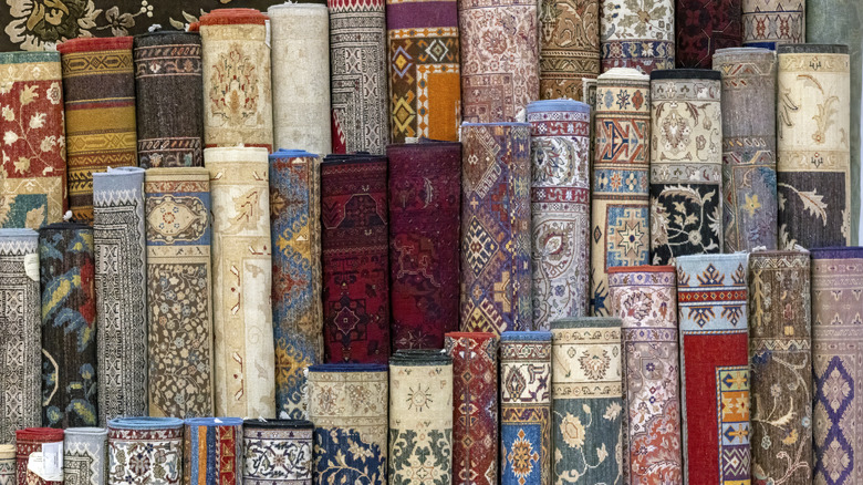 Farklı tarzlarda ve renklerde çoklu yuvarlanmış Türk halıları