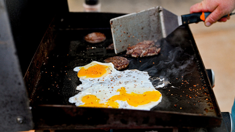 Kişi Blackstone ızgarasında kahvaltı yemeği yemek