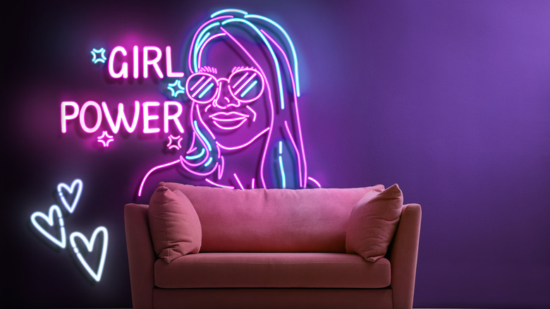 Bir kadının tasviriyle, bir kanepenin arkasında büyük bir neon işareti okuma kız gücü