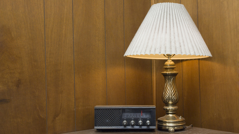 Masadaki eski bir radyonun yanında yanan bir vintage lamba