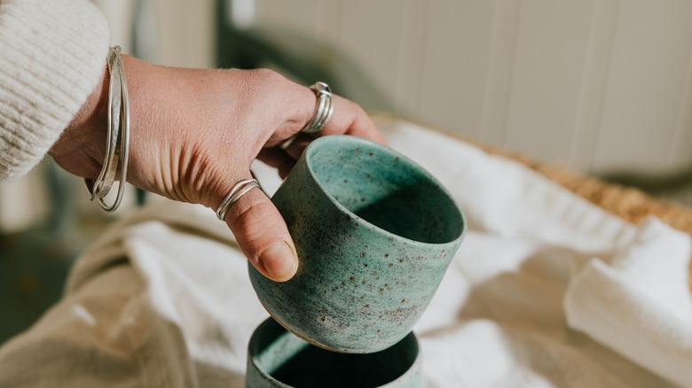 Yeşil seramik anne tutan kişi