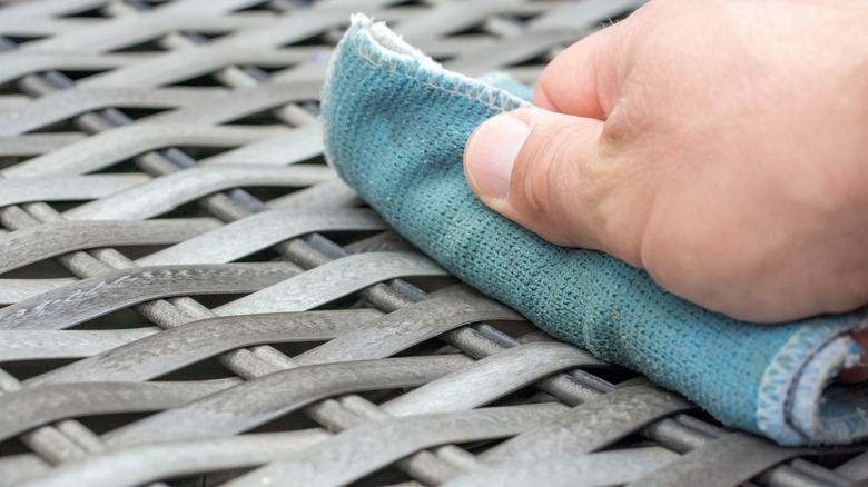 Bir bezle hasır mobilyaları siliyor