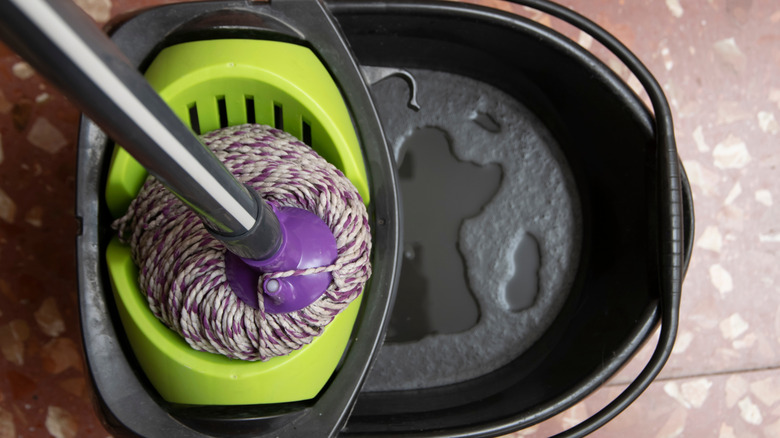 Terrazzp karo zeminlerine yerleştirilmiş bir kova ve paspas.