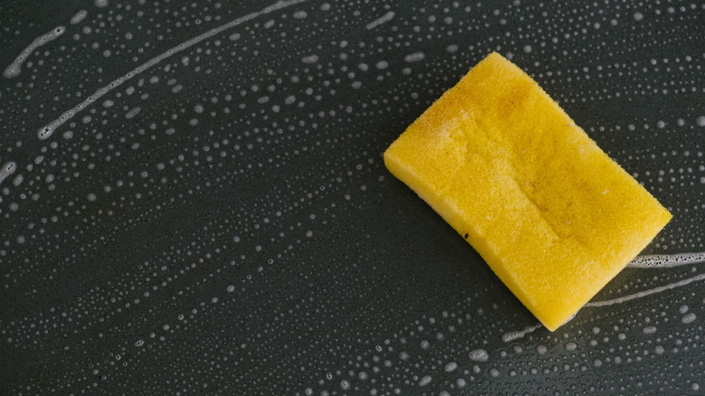 Bir yüzeyi temizlemek için bir sünger ve bulaşık sabunu kullanmak