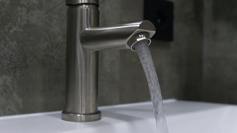 Bir lavaboya akan fırçalanmış nikel musluk.