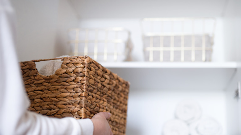 Rafa hasır sepet yerleştiren kişi