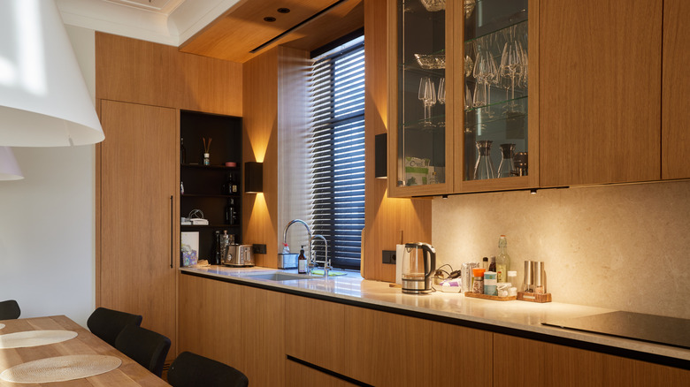 Ahşap ve cam ön dolapları ile modern mutfak