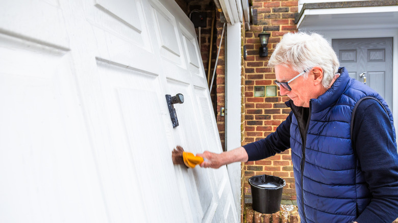 Garaj kapısını temizleyen yaşlı bir adam