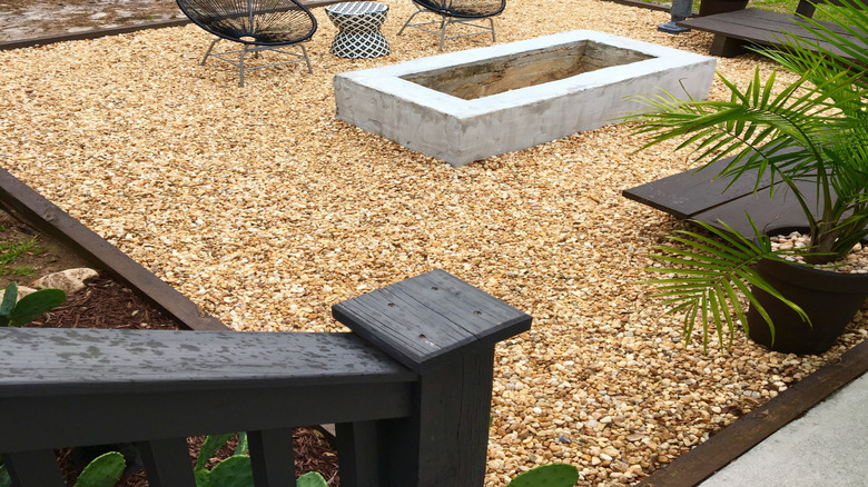 Bir bezelye çakıl veranda sandalyelerin, bankların ve bir ateş çukurunun altında oturuyor.