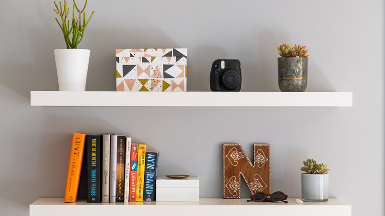 Kitap ve bitkilerle beyaz yüzen raflar