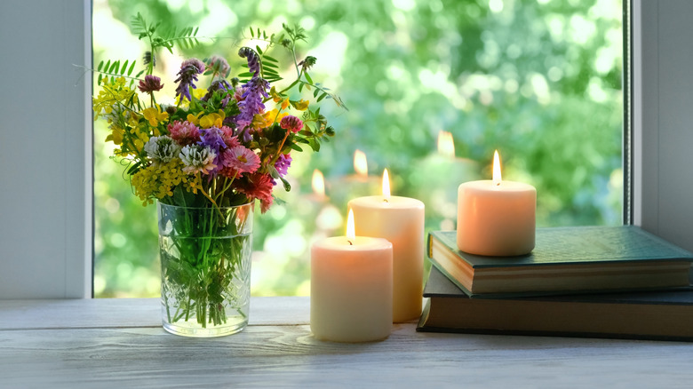 Pencerelerde mumlar ve çiçekler