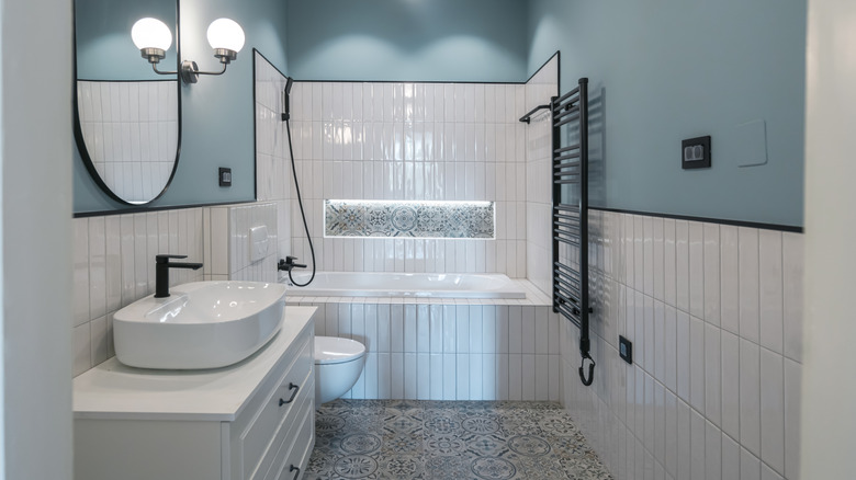 Yarım döşemeli duvarları ve mavi boyalı modern banyo