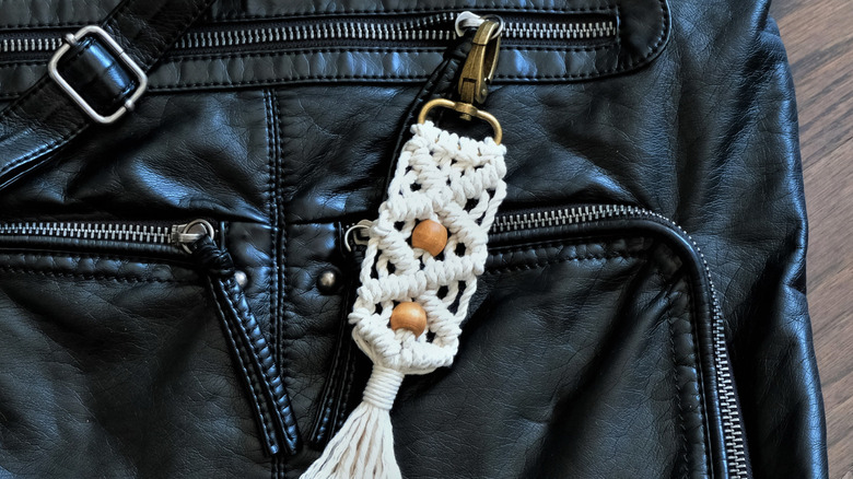 Fermuarlı siyah çanta üzerinde beyaz ve boncuk anahtarlık